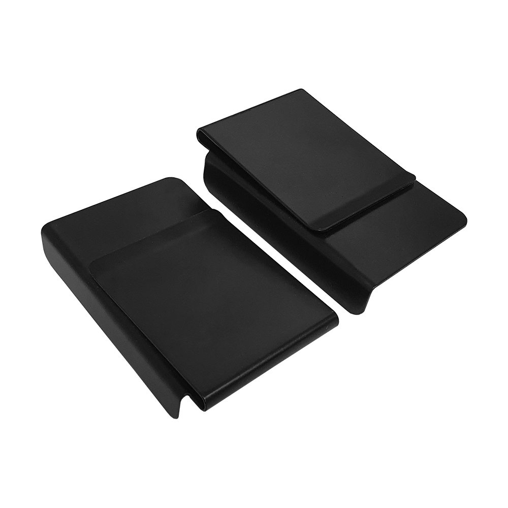 8208_Winmau_Sabre_Oche_Master_5 Das Bild zeigt zwei schwarze Kunststoffteile des Produkts 'Winmau Sabre Oche Master'. Sie sind rechteckig und haben eine gebogene Form.