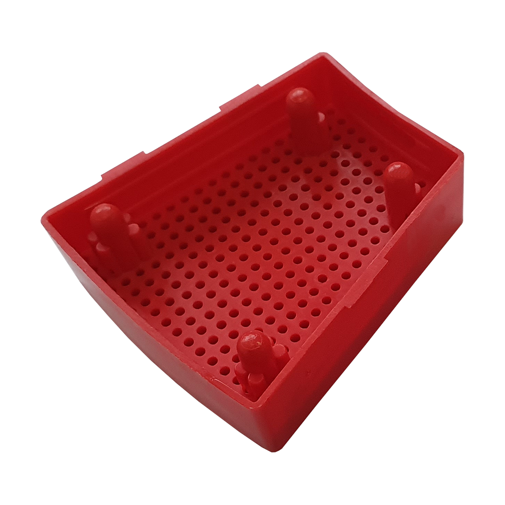 GRN0151_Granboard_132_Ersatzfelder_Single_Aussen_Rot_3 Das Bild zeigt ein rotes Ersatzfeld für das Granboard 132. Das Kunststoffteil hat eine rechteckige Form mit vielen kleinen Löchern und vier Erhebungen.