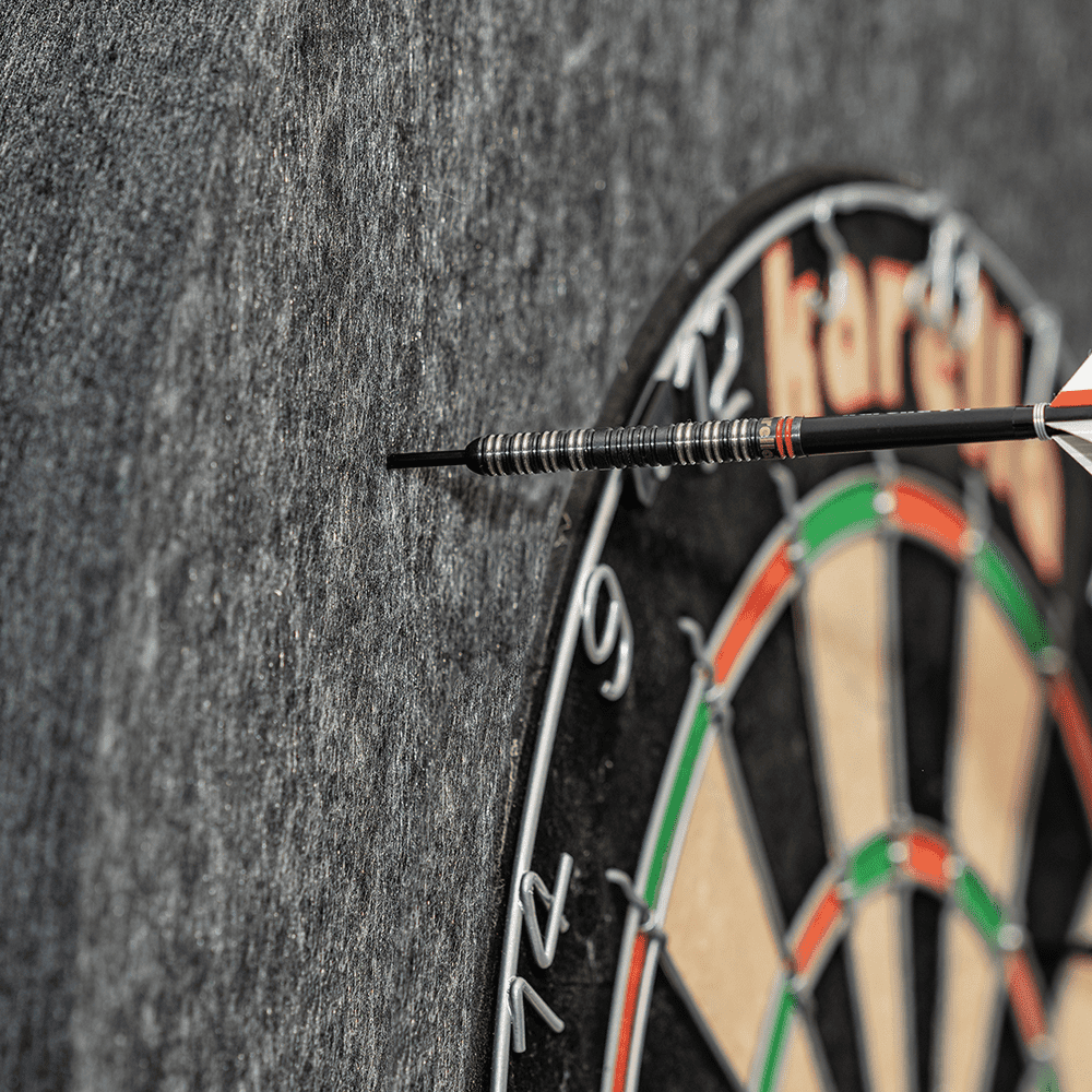 811501_Karella_Schallschutz_f-r_Steeldartboards_5 Das Bild zeigt ein Steeldartboard mit dem Schallschutz Karella und integriertem Surround Auffangring. Ein Dartpfeil steckt in dem schallschluckenden Auffangring neben der Dartscheibe.