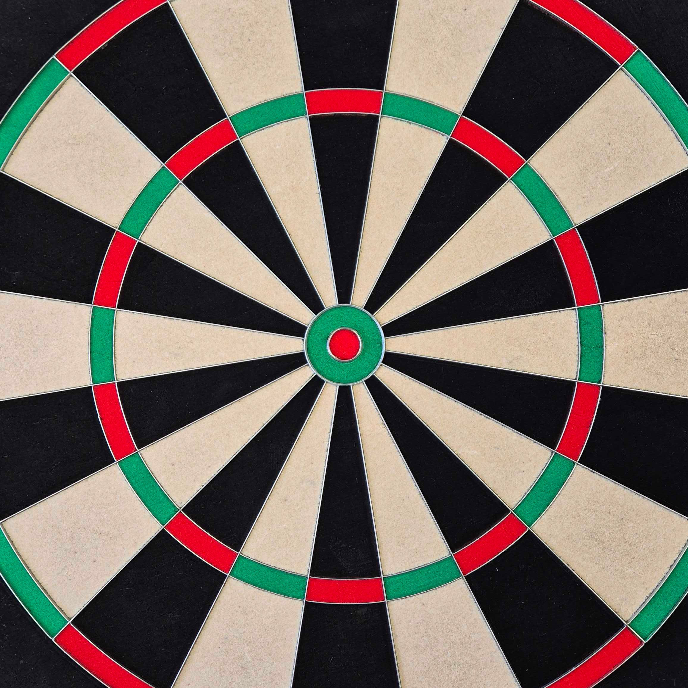 Das Bild zeigt ein McDart Precision Steeldartboard. Die Dartscheibe ist in schwarze, beige, grüne und rote Segmente unterteilt.