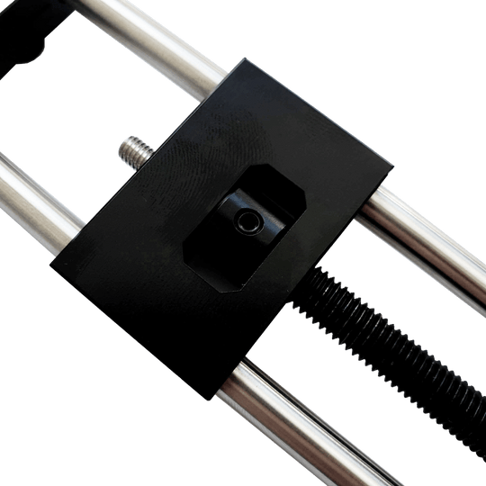 McDart Repointer Pro Das Bild zeigt das Produkt "McDart Repointer Pro" mit einer Nahaufnahme des Mechanismus. Zu sehen sind zwei Metallstangen und ein schwarzes Gehäuse mit einer Schraube in der Mitte.