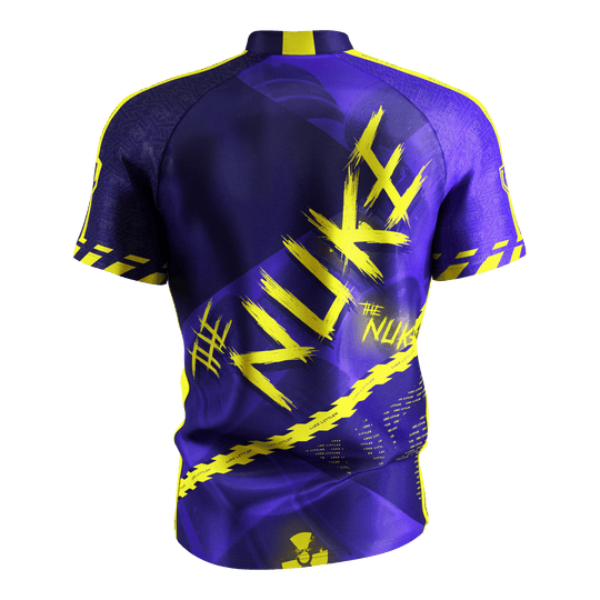 Target Coolplay Luke Littler 2025 dart shirt Das Bild zeigt das „Target Coolplay Luke Littler 2025 Dartshirt“ von hinten. Das Shirt ist überwiegend lila mit auffälligen gelben Designs und dem Schriftzug „NUKE“ auf dem Rücken.