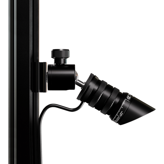 Target MOD Laser Oche Das Bild zeigt das Produkt "Target MOD Laser Oche", das an einer vertikalen Stange befestigt ist. Es handelt sich um ein schwarzes, zylindrisches Gerät mit einem Kabelanschluss und feinen Details.