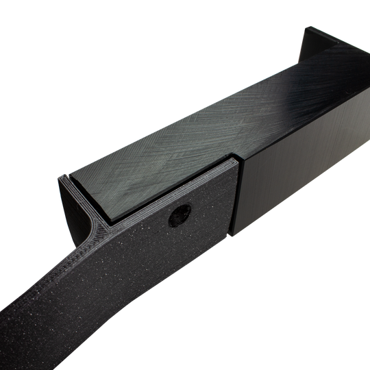 MC_Scolia_Abstandshalter_zur_Wandmontage_4 Das Bild zeigt einen schwarzen Abstandshalter zur Wandmontage, der für das Scolia Home 1 System verwendet wird. Das Produkt besteht aus stabilem Material und hat eine rechteckige Form mit einer Befestigungsöffnung.