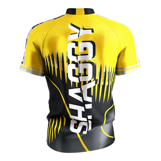 Target Coolplay Scott Williams 2025 dart shirt Das Bild zeigt ein gelb-schwarzes Dartshirt mit dem großen weißen Schriftzug "SHAGGY" auf der Rückseite. Das Shirt hat ein auffälliges, modernes Design mit dynamischen Linien und Mustern.