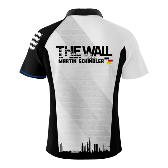 Das Bild zeigt das "Bulls Martin Schindler The Wall Dartshirt" von hinten. Auf dem Shirt steht "THE WALL MARTIN SCHINDLER" mit einer kleinen Deutschlandflagge und einer Stadtsilhouette darunter.