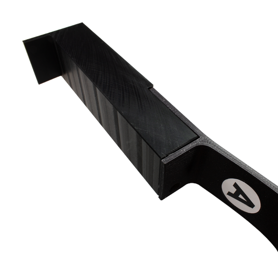 MC_Scolia_Abstandshalter_zur_Wandmontage_3 Das Bild zeigt einen schwarzen Abstandshalter zur Wandmontage für das Scolia Home 1. Das Produkt hat eine eckige Form und trägt ein weißes Logo an der Seite.