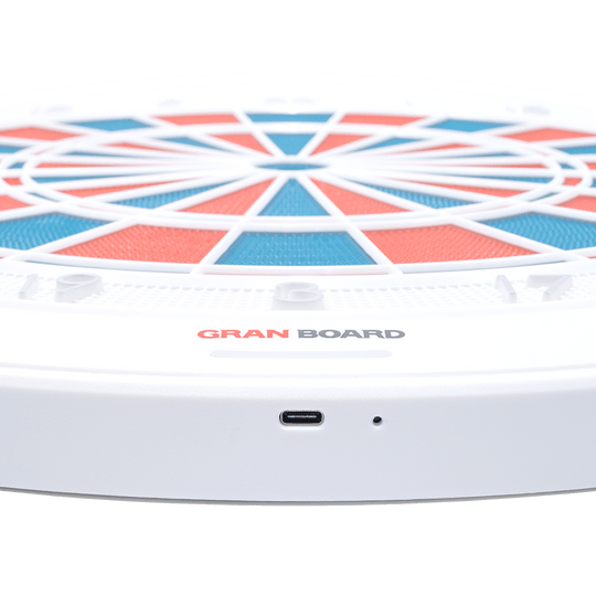 g01440_GranBoard_132_Elektronisches_Dartboard_3 Das Bild zeigt das elektronische Dartboard „GranBoard 132“ mit einem modernen, farbigen Design. Im Vordergrund ist der USB-Anschluss des Geräts gut sichtbar.